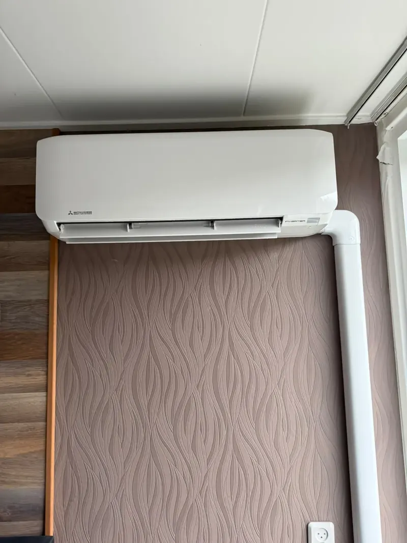 Witte airco binnenunit strak boven een raam gemonteerd in Ypenburg, Den Haag