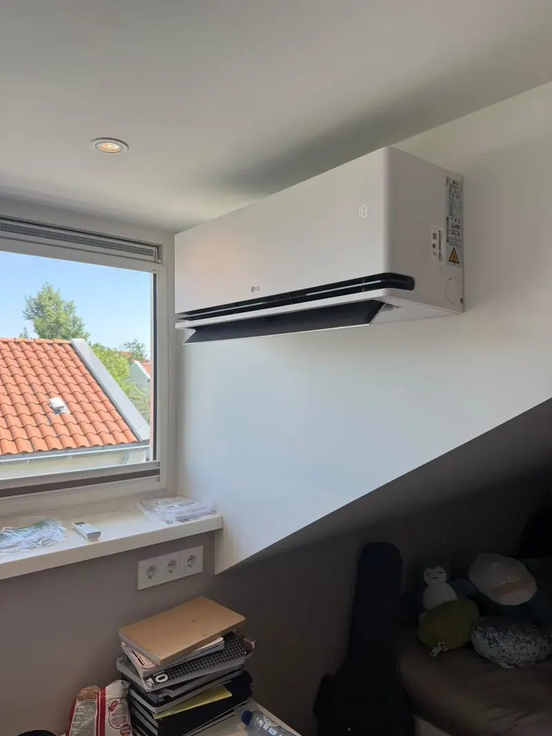 Airco binnenunit geplaatst naast een raam in een slaapkamer in Voorburg
